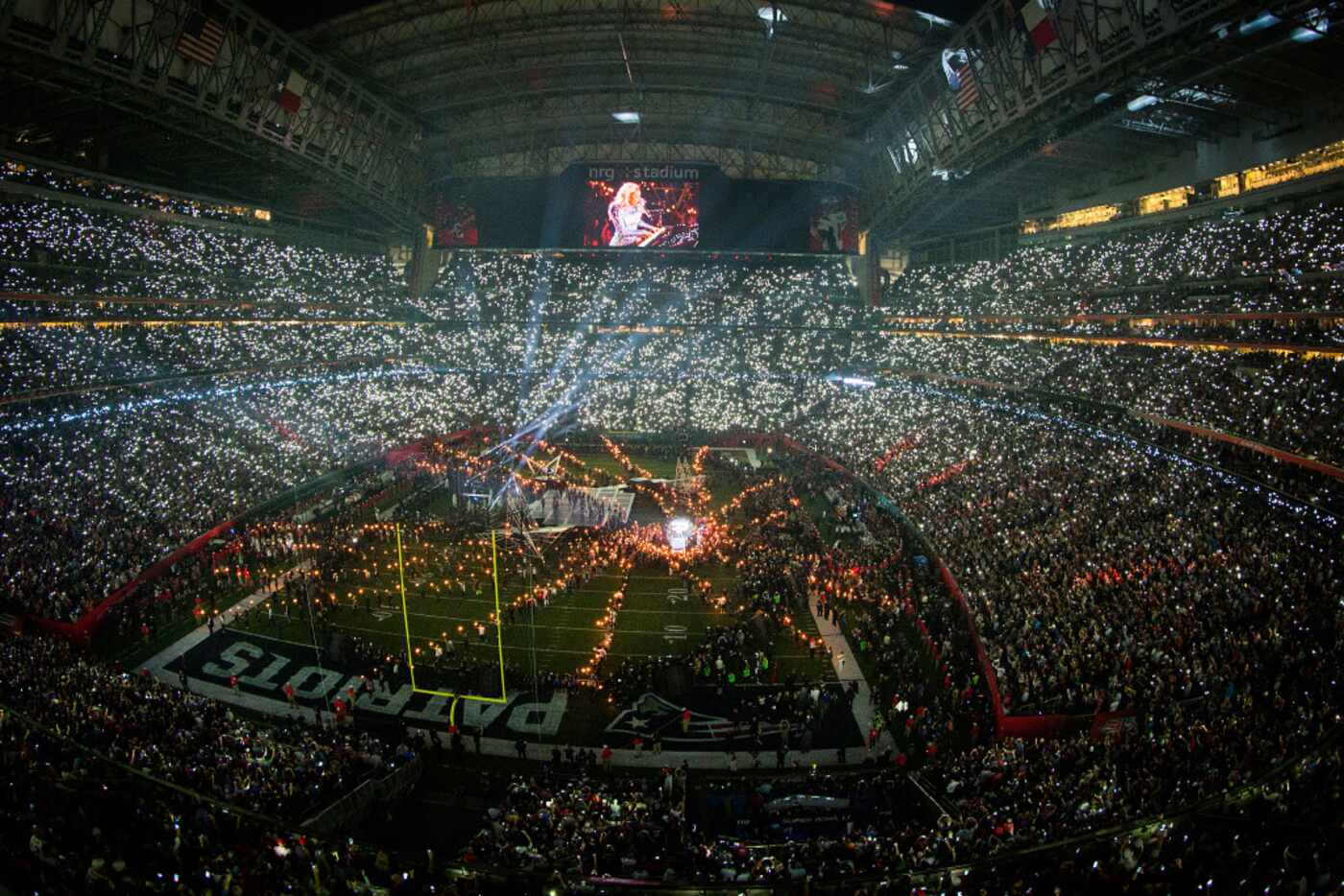 Audience flashlights light up the stadium as Lady Gaga performs during halftime of the Super...