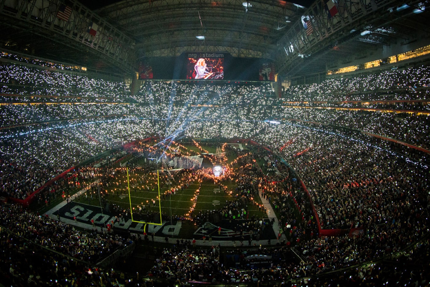 Audience flashlights light up the stadium as Lady Gaga performs during halftime of the Super...