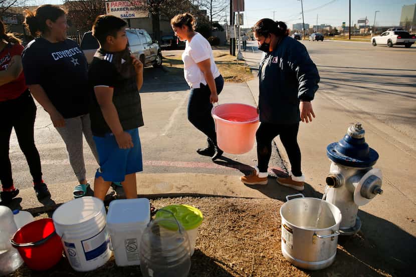 Dallas residents Maria Mata (right) and her daughter Dariela Mata carried a large bucket of...
