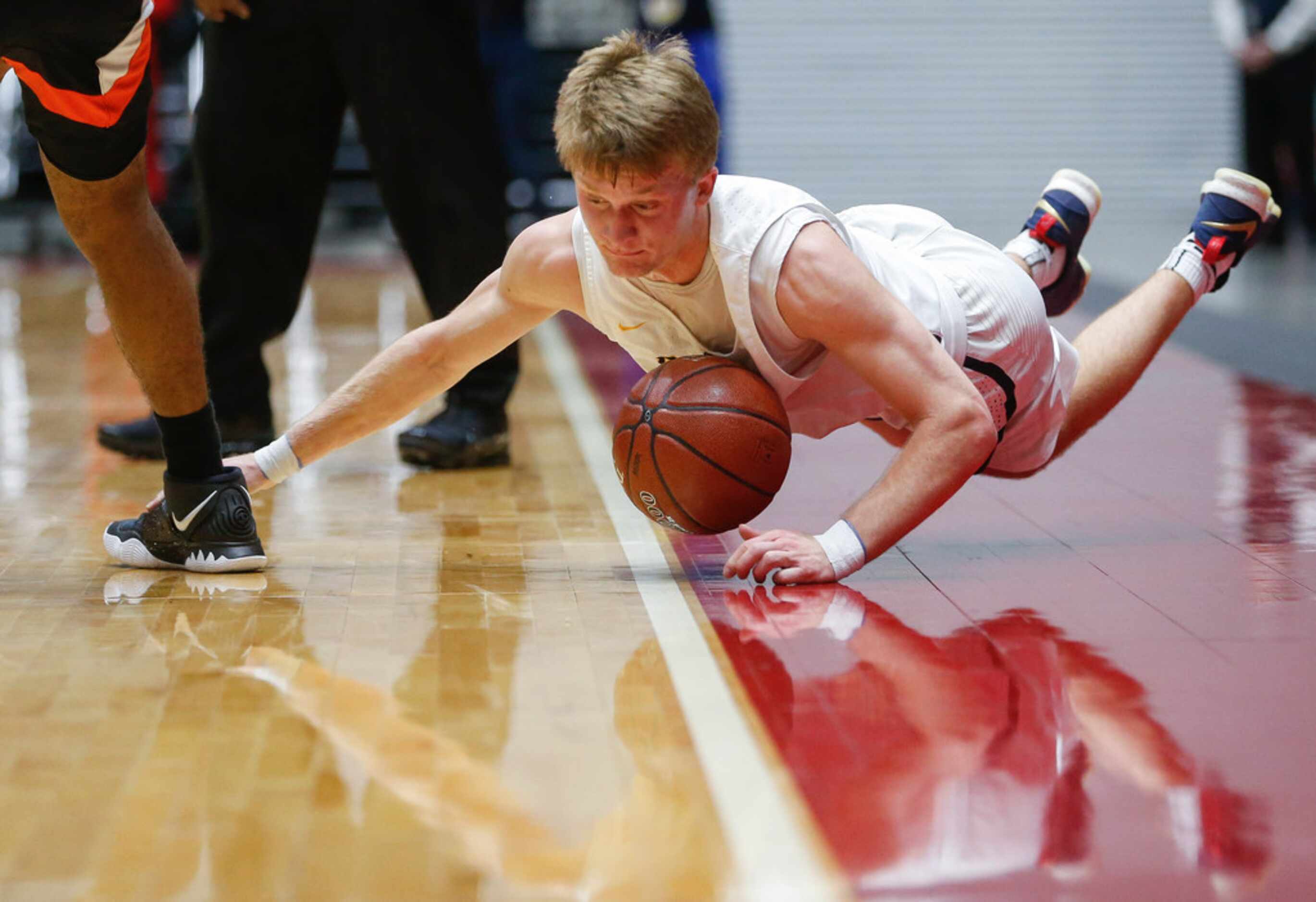 Highland Park's Drew Scott (5) slides out of bounds while grappling with Lancaster's Marco...