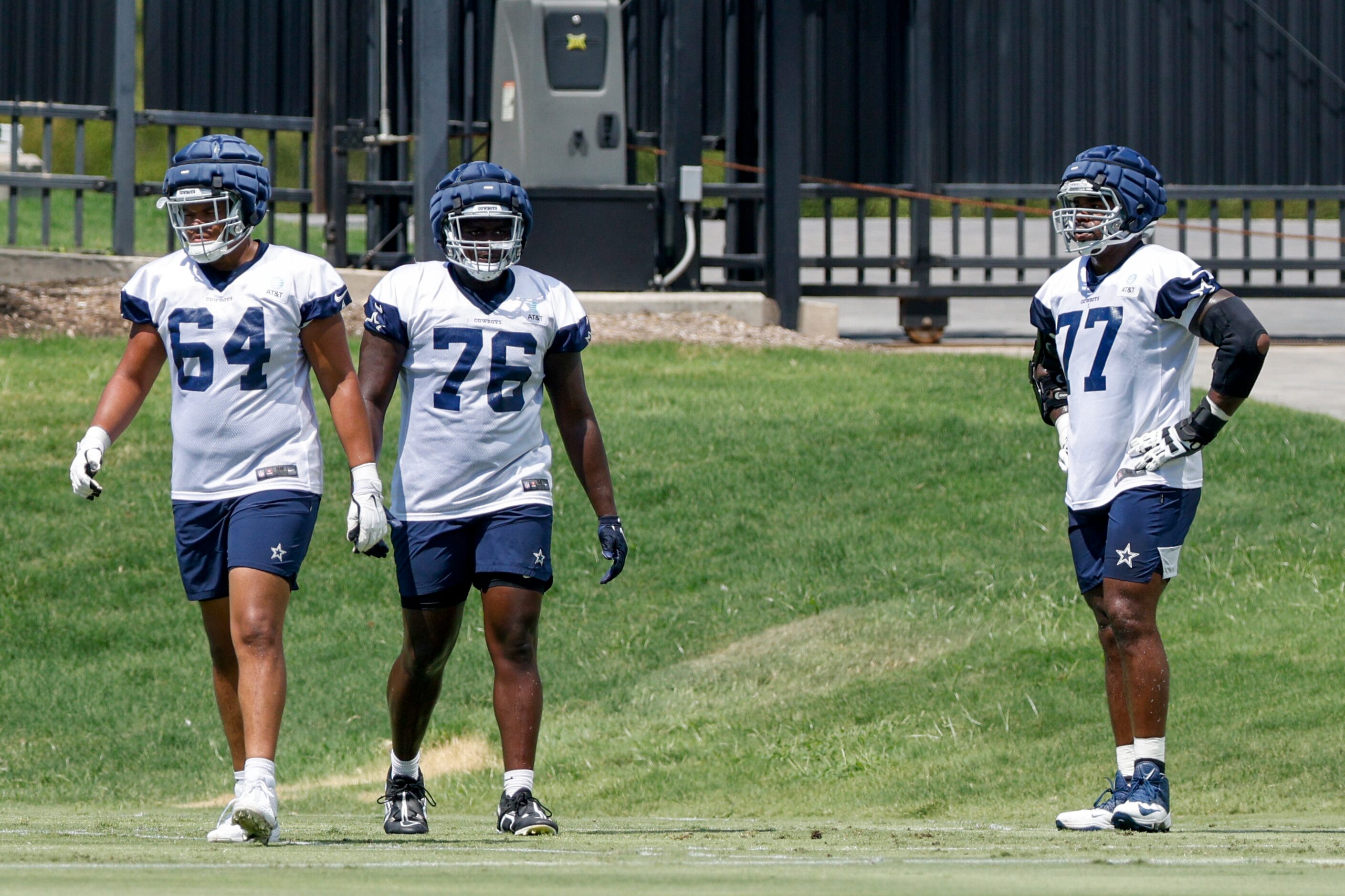 Dallas Cowboys offensive tackle Tyron Smith (77) watches practice alongside Earl Bostick Jr....