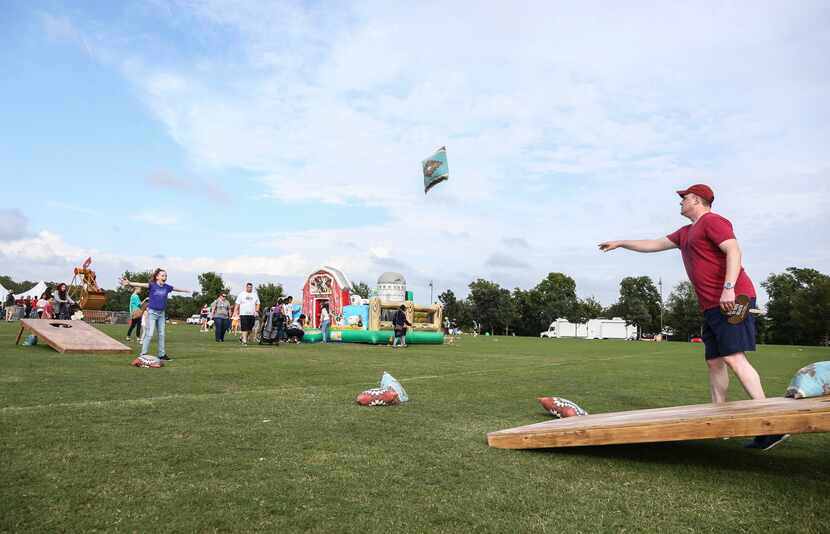 Leyna Anderson spreads her arms out as her father Mike Anderson throws a giant bean bag...