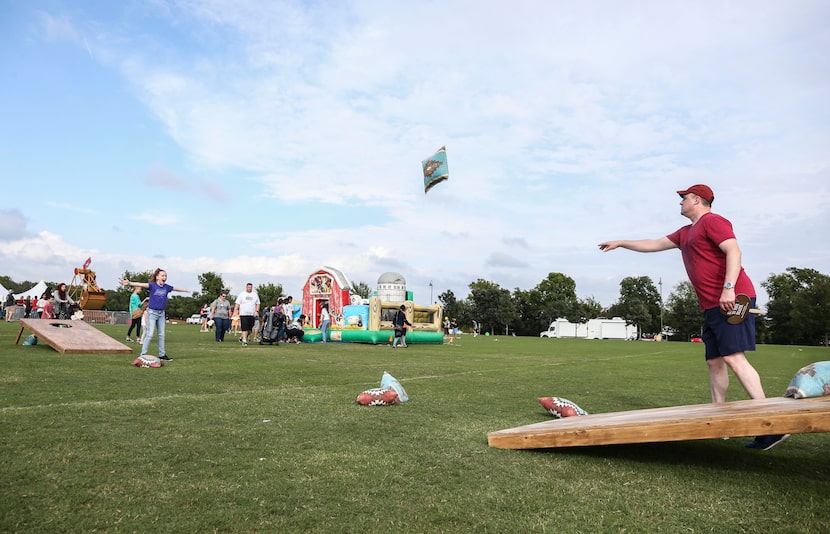 Leyna Anderson spreads her arms out as her father Mike Anderson throws a giant bean bag...