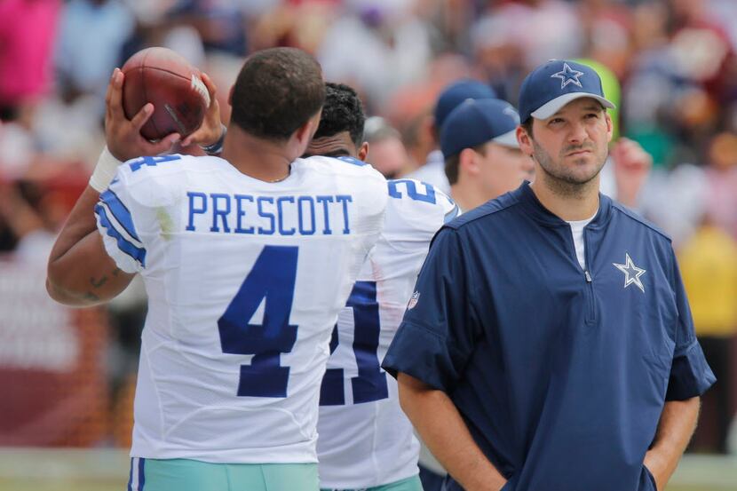 Dallas Cowboys quarterback Dak Prescott (4) and quarterback Tony Romo (9) watch from the...