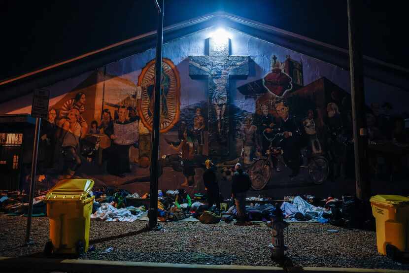 Migrants spend the night on the street at the Centro Pastoral Sagrado Corazon in El Paso on...