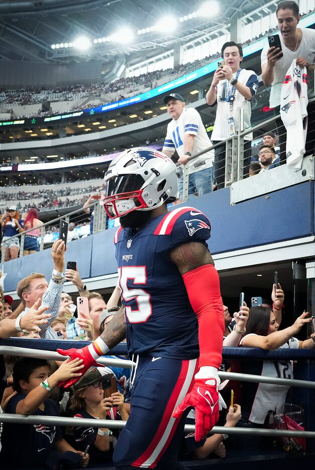 New England Patriots running back Ezekiel Elliott (15) takes the field to warm up before an...