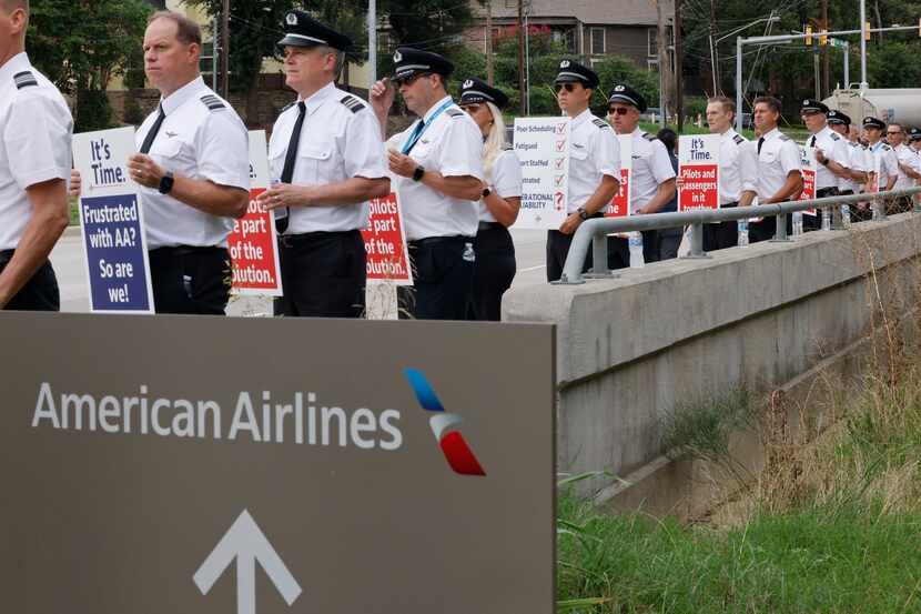 American Airlines pilots with the Allied Pilots Association stand along Trinity Boulevard...