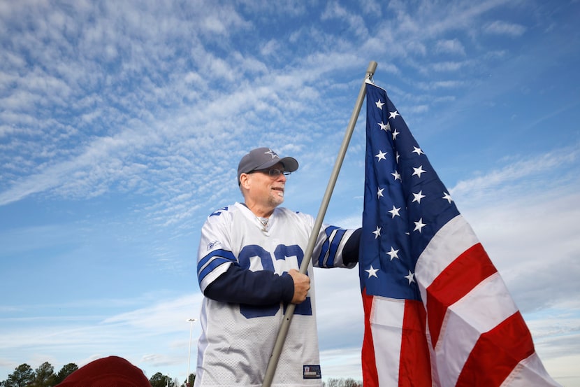 Dallas Cowboys fan Dwayne Millsaps of North Carolina sets up an American flag on his truck...