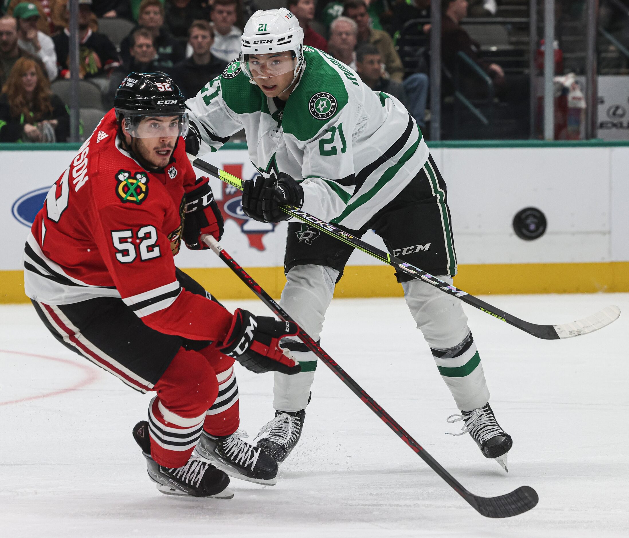 Chicago Blackhawks center Reese Johnson (52) and Dallas Stars left wing Jason Robertson (21)...