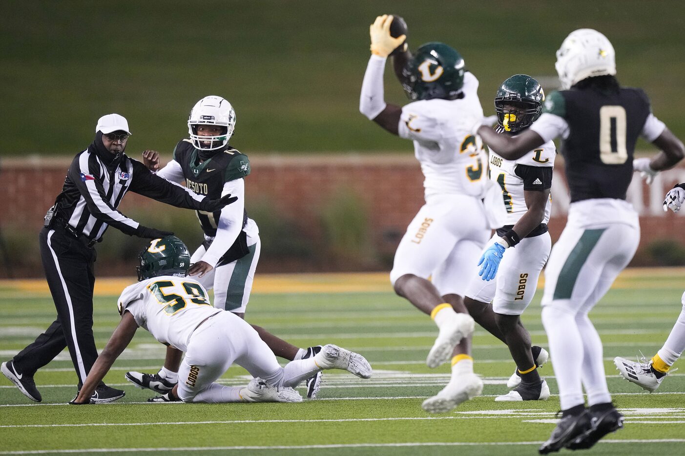 DeSoto quarterback Legend Howell (14) watches as a pass intended for Myson Cook-Johnson (0)...