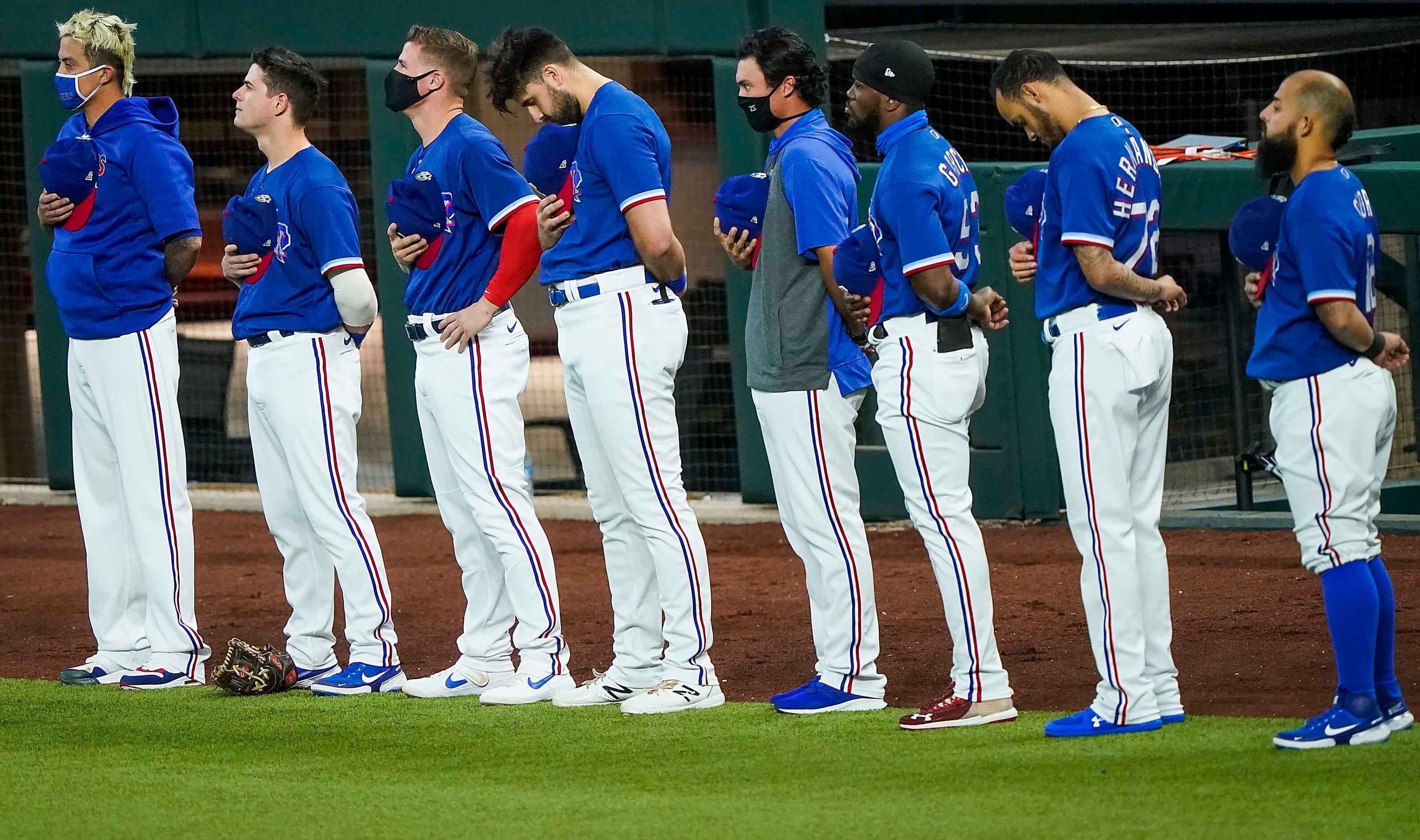 Texas Rangers players stand for the national anthem before exhibition game against the...