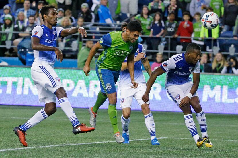 Seattle Sounders midfielder Lamar Neagle, center, heads the ball in for a goal against FC...