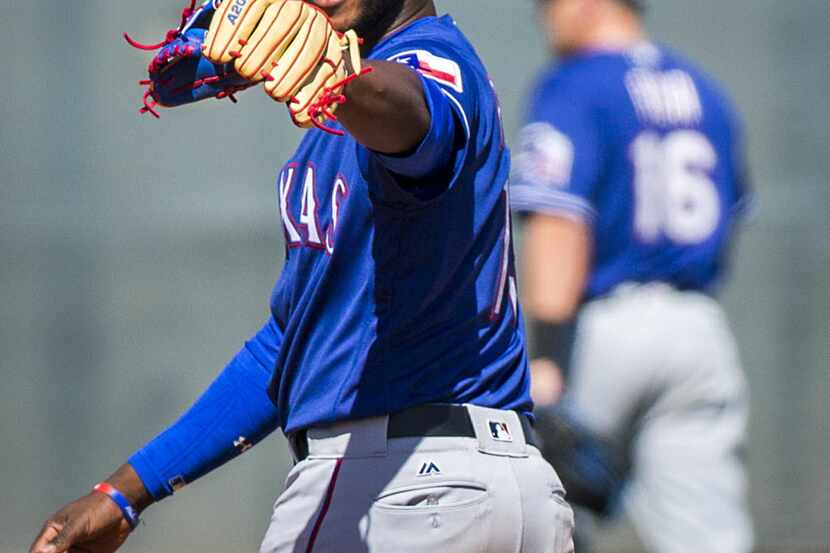 Texas Rangers infielder Jurickson Profar celebrates after making an off balance throw to get...