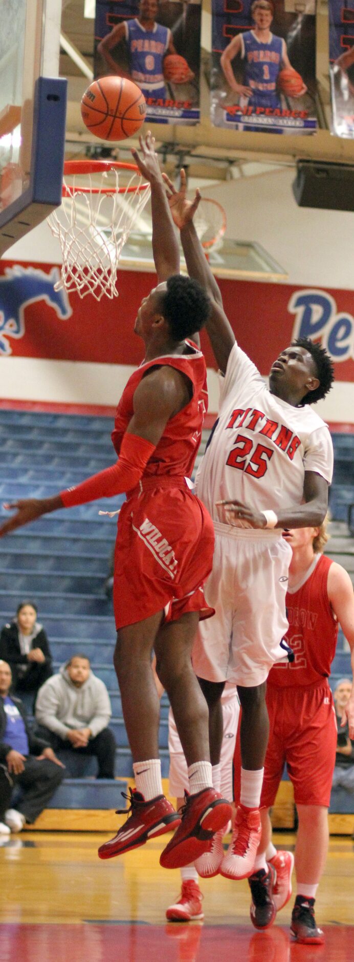 Woodrow Wilson's Hassan Thomas (3) drives strong to the basket as he shoots over the defense...