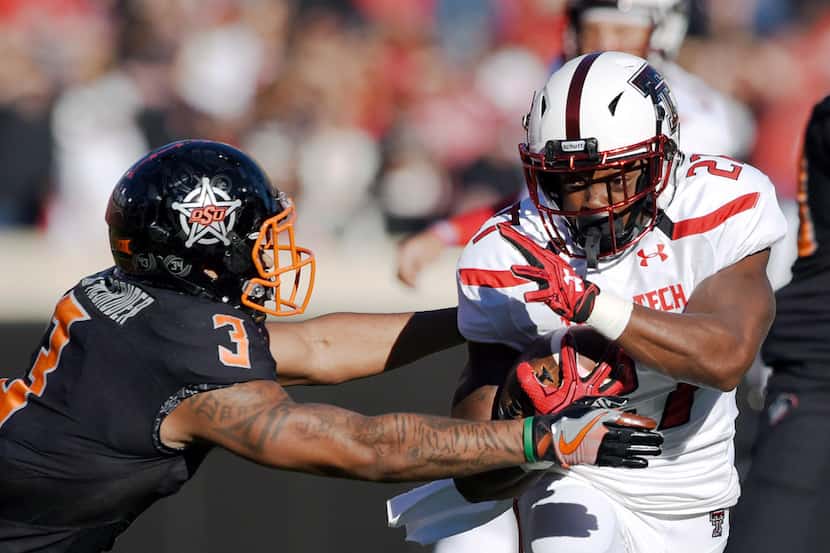 Oklahoma State safety K. Edison McGruder (3) reaches for Texas Tech running back Demarcus...