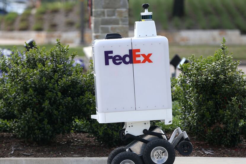The FedEx same-day bot ascends a curb during a demonstration outside the FedEx Office...