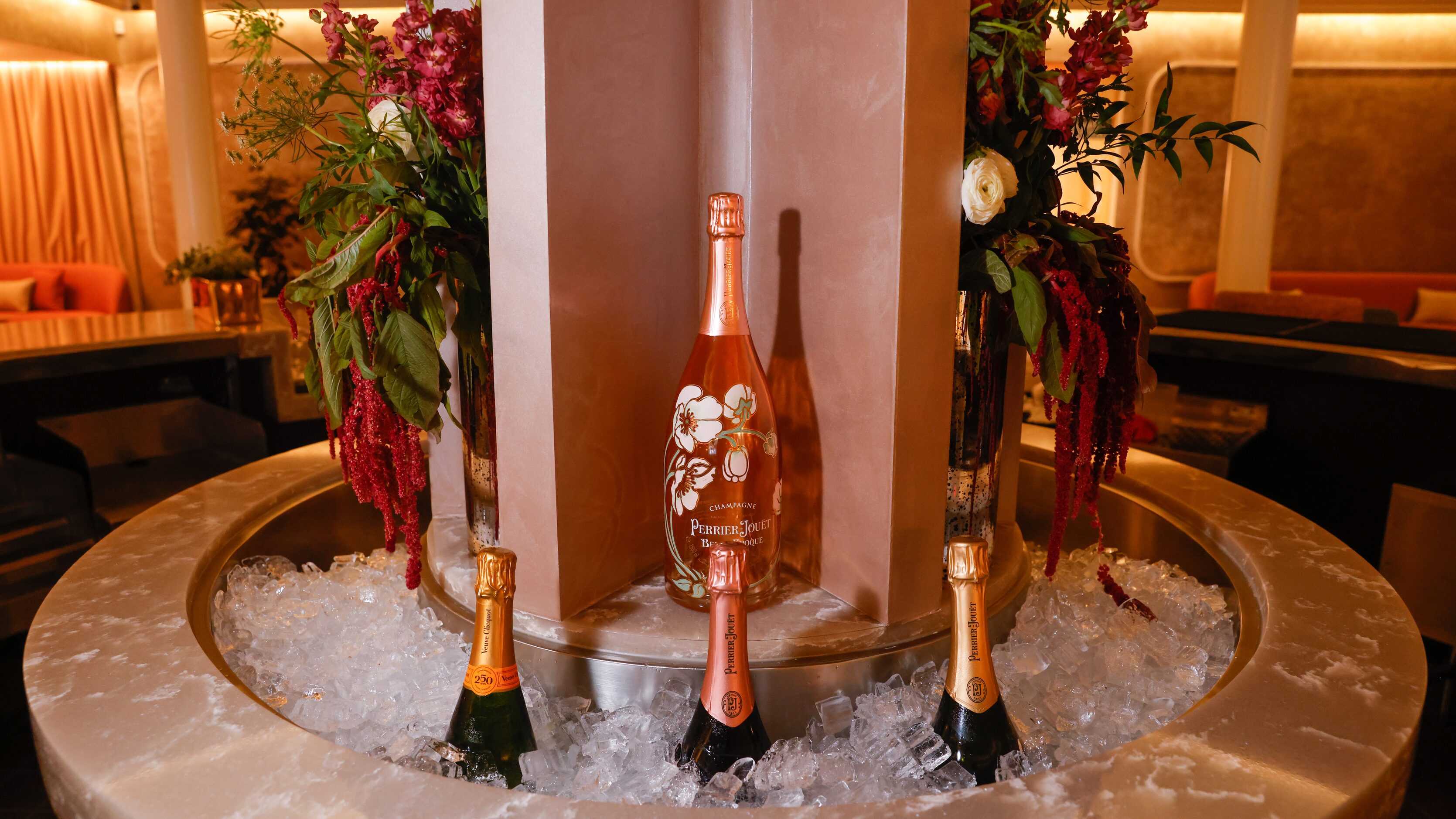 A round ice trough chills champagne in the center the bar of Coupes in Dallas on Friday,...