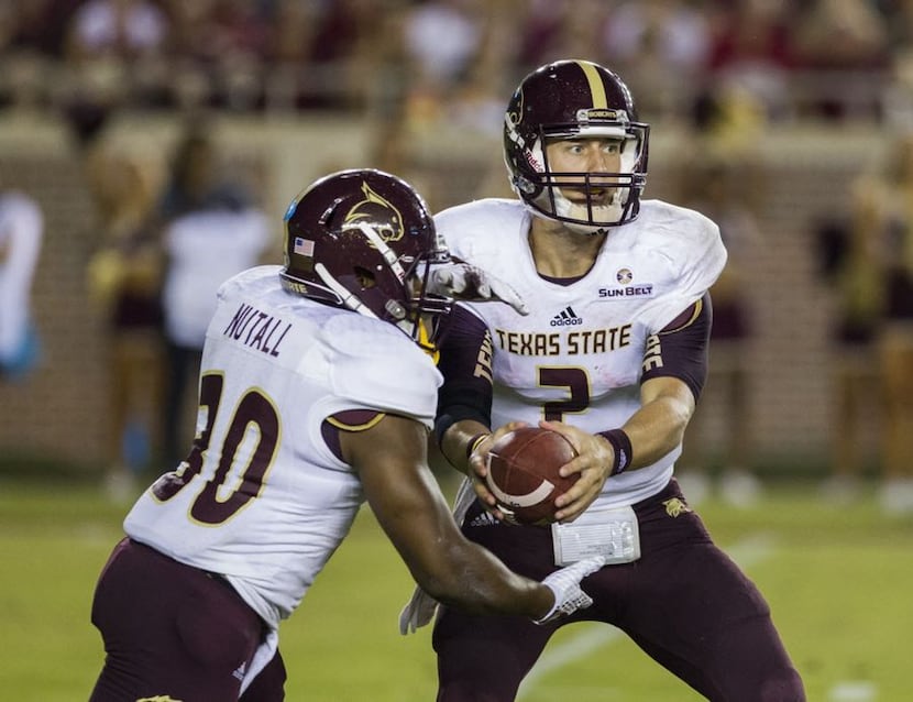 Texas State quarterback Tyler Jones fakes a handoff to Chris Nutall during the first half of...