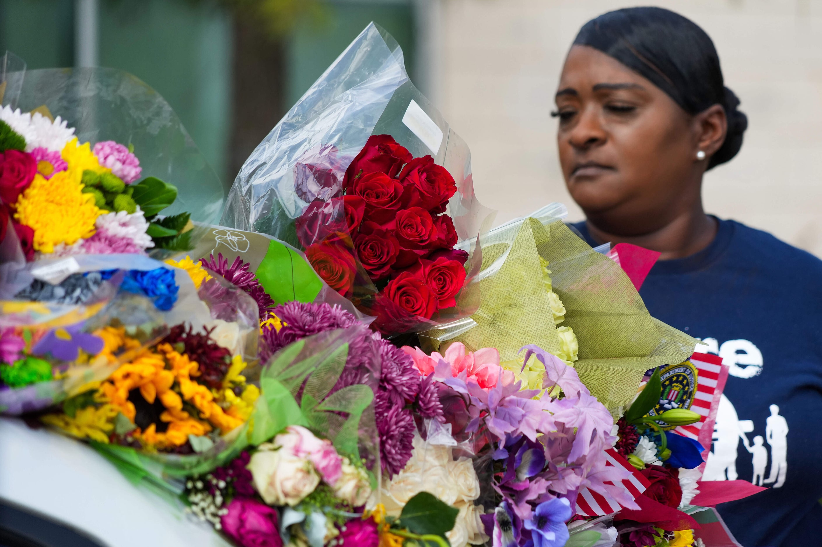 Patricia Allen places roses on a Dallas police patrol car serving as a memorial to slain...