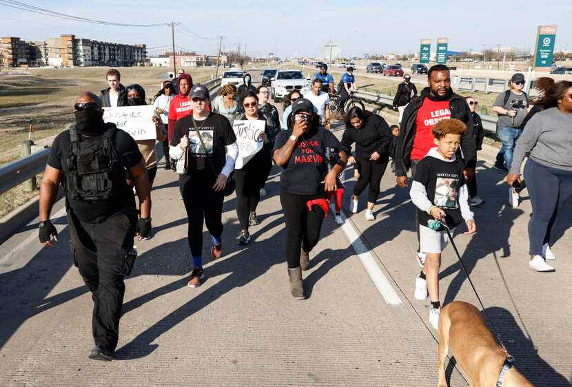 Demonstrators march on the U.S. Highway 75 service road Sunday, March, 13, 2022 in Allen,...