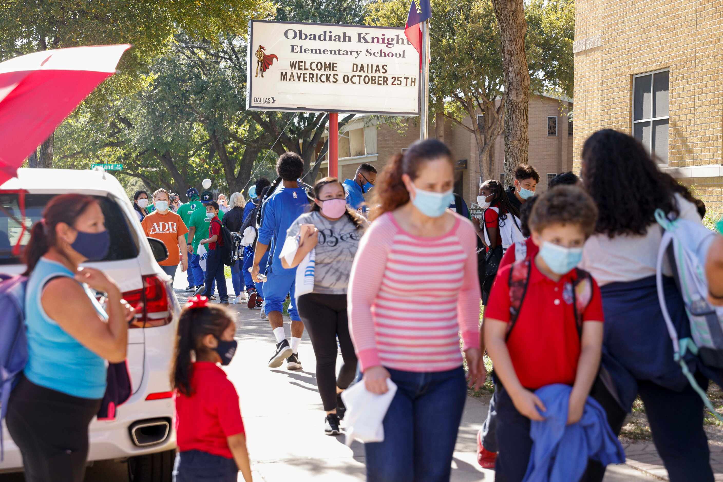 Family members walk students after the end of classes at Obadiah Knight Elementary School on...
