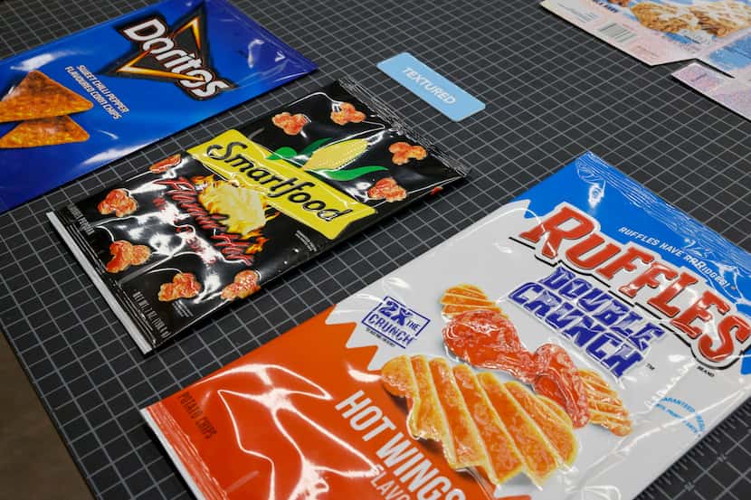 Textured film used for packaging various snacks is displayed on a table in the packaging and...