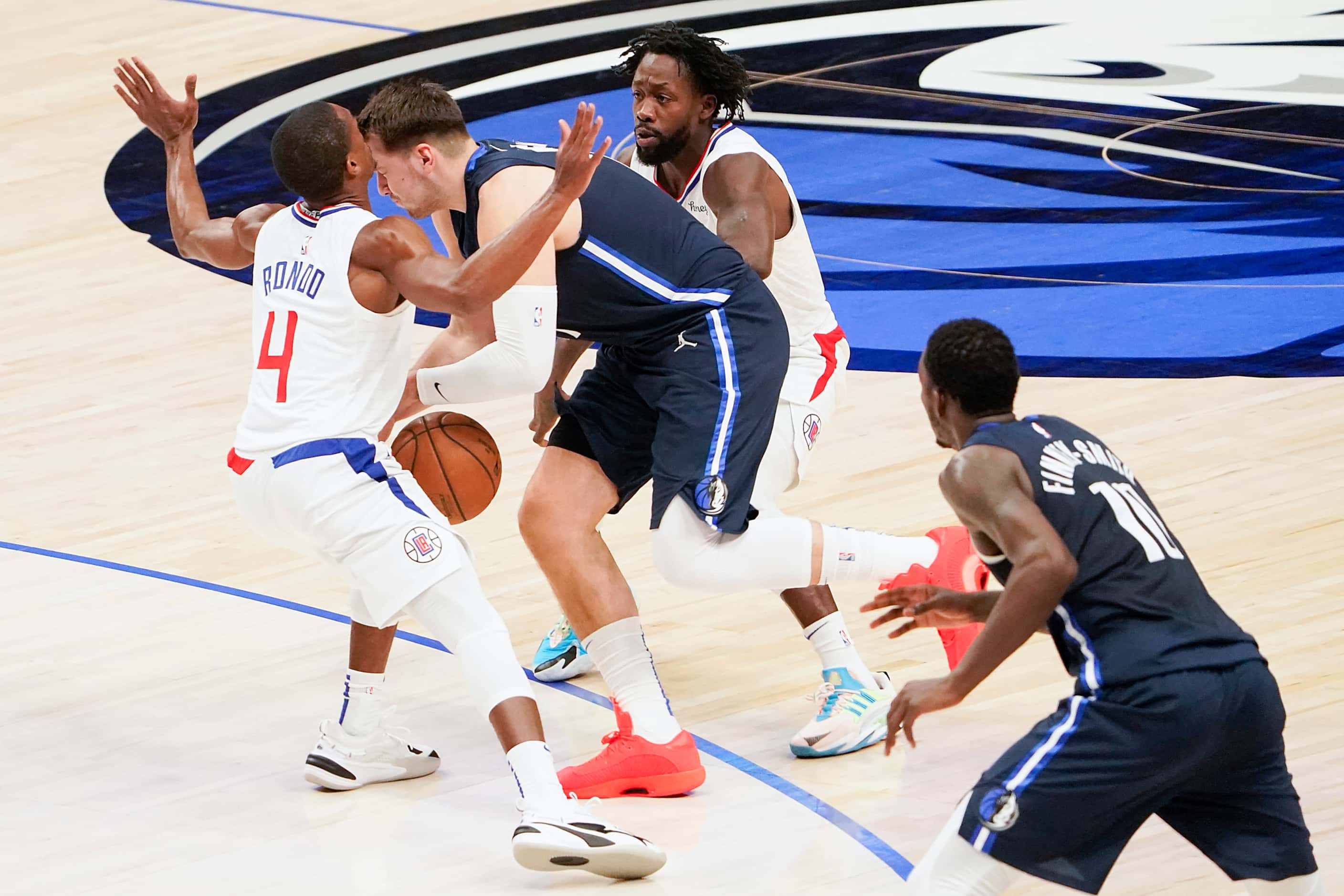 Dallas Mavericks guard Luka Doncic (77) collides with LA Clippers guard Rajon Rondo (4) as...