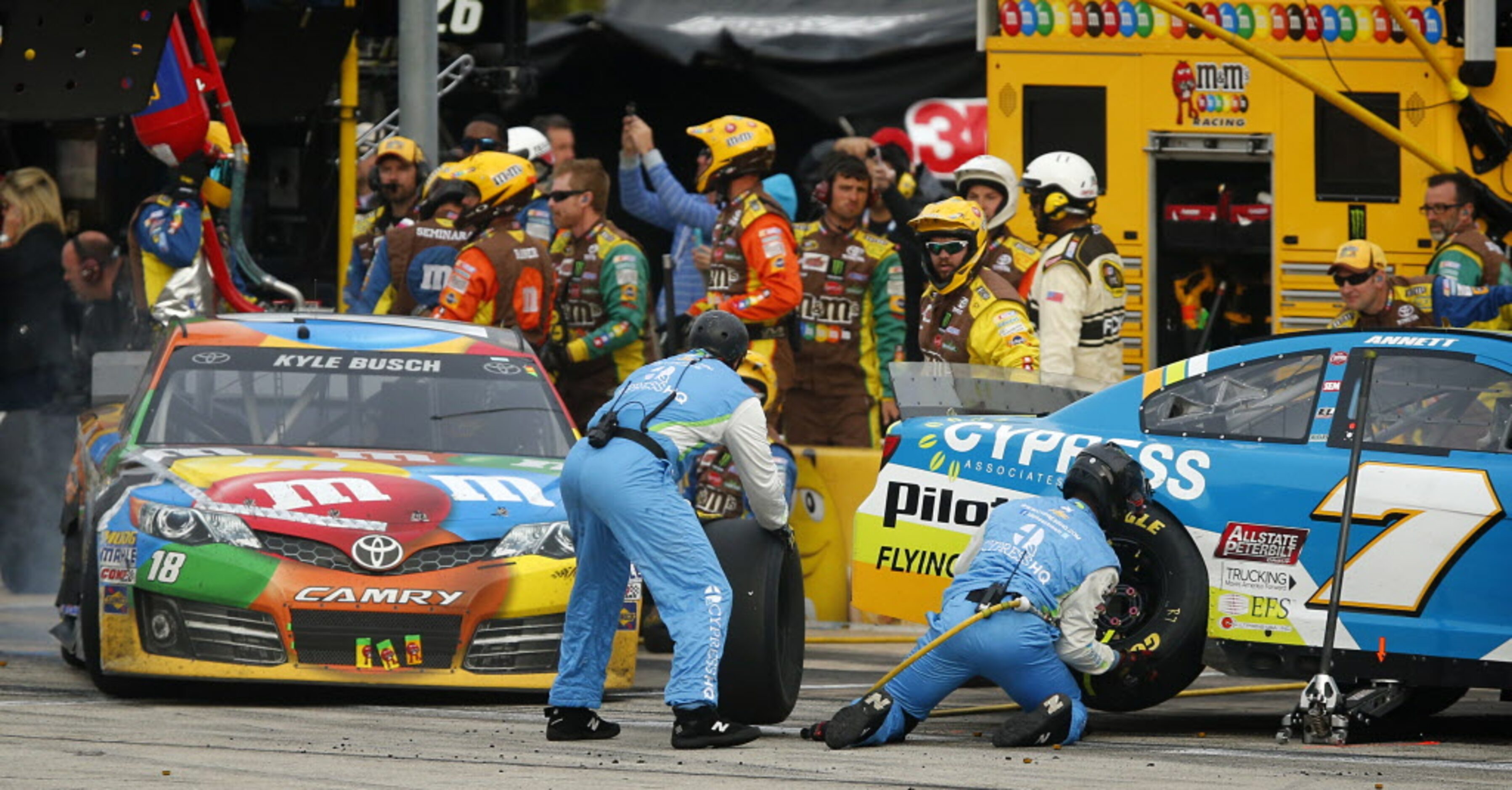 Crewman for the Sprint Cup Series driver Michael Annett (7) try to avoid driver Kyle Busch...