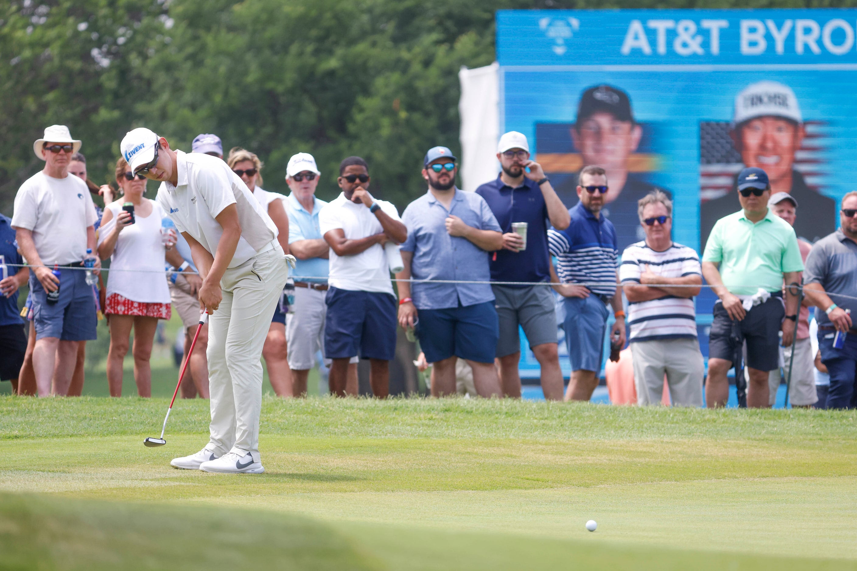 People watch as S.Y. Noh of South Korea putts on the 18th hole green during the second round...