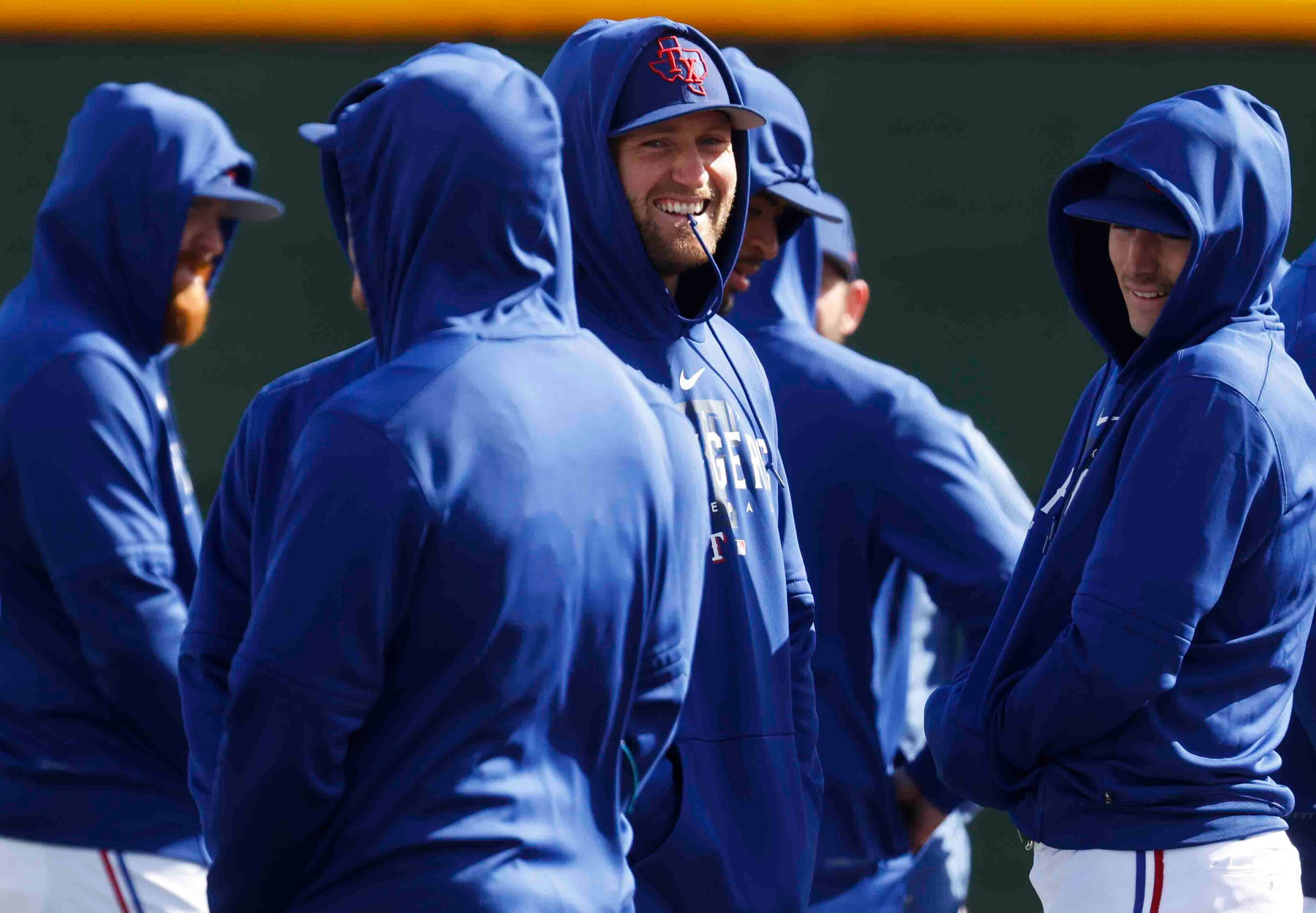 Texas Rangers pitcher Lucas Jacobsen, center, alongside others wait to warm up during a...