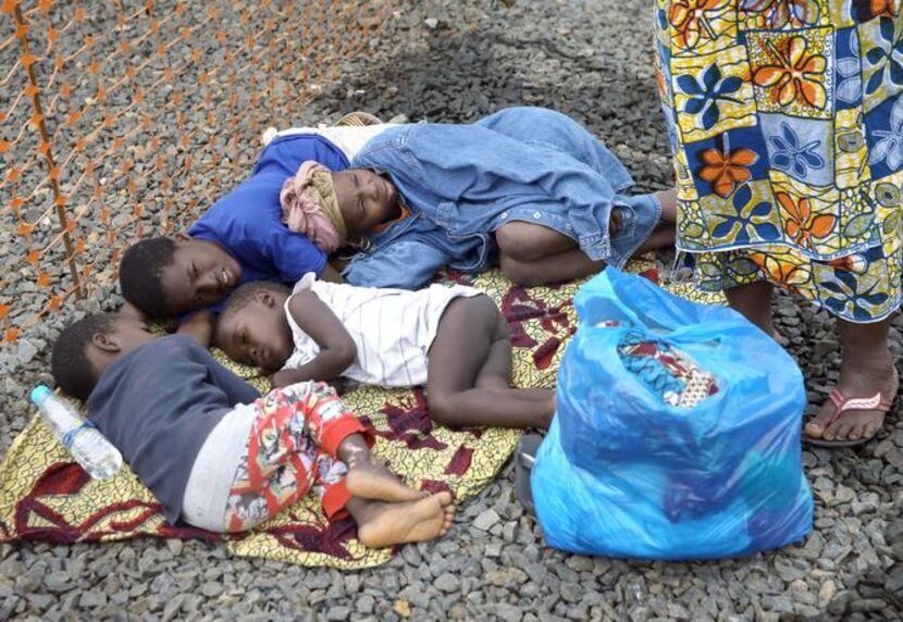 
Children in Monrovia, Liberia, lay on the ground Thursday while waiting to be admitted to...