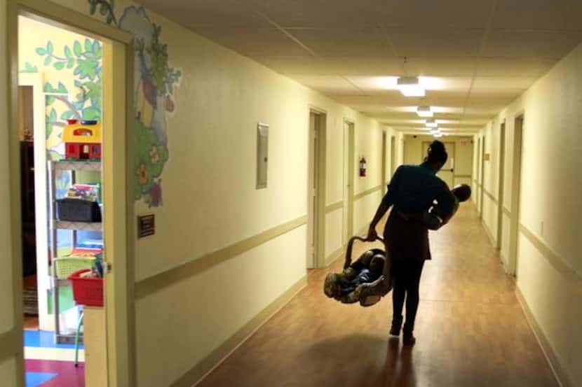 

A resident carries her twins to her room at the Samaritan Inn in McKinney.



