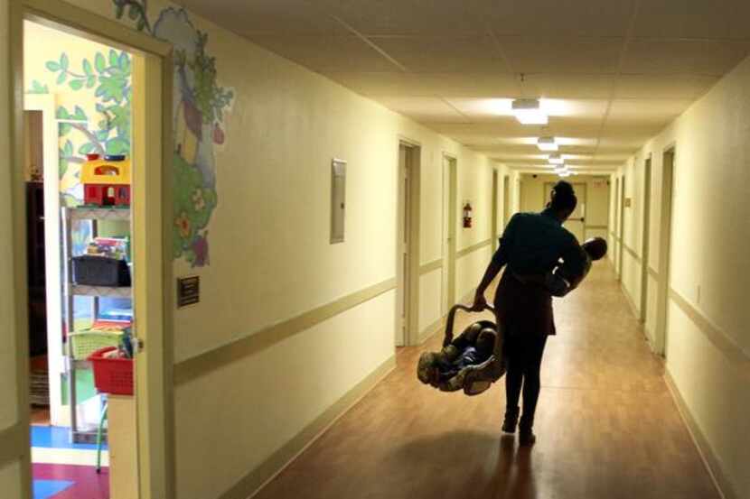 

A resident carries her twins to her room at the Samaritan Inn in McKinney.


