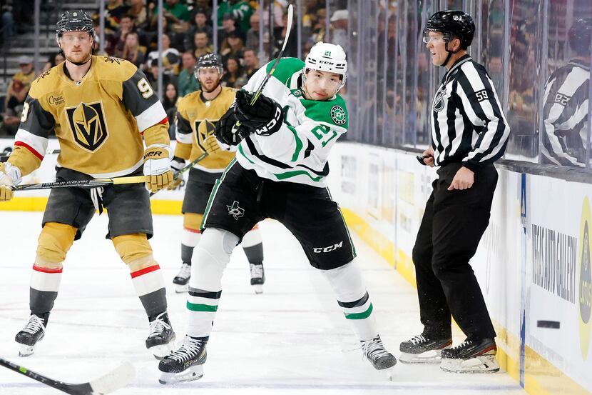 Dallas Stars left wing Jason Robertson (21) flings the puck along the boards against the...