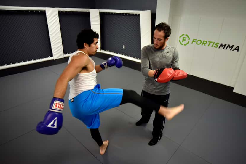 Legacy fighter Damon Jackson, 28, right, trains Ricky Romo, 20, inside the cage room at the...