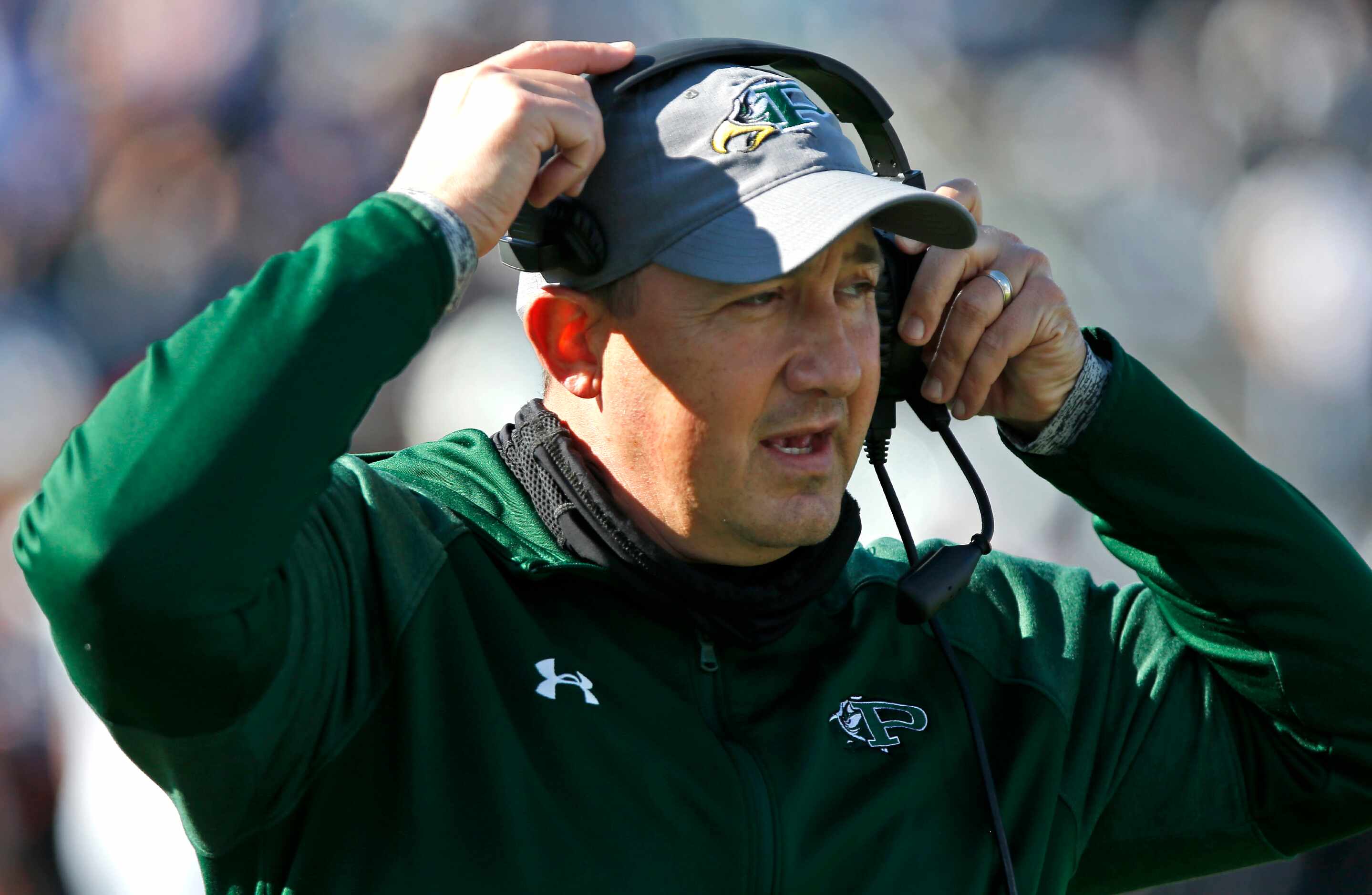 Prosper High School head coach Brandon Schmidt talks to coaches upstairs during the first...