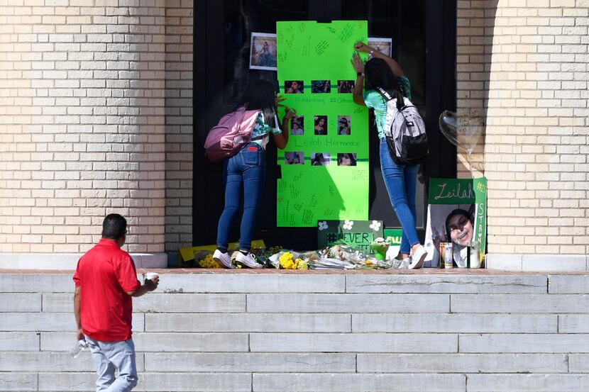 Students write their thoughts on a memorial for Leilah Hernandez on the front steps of...