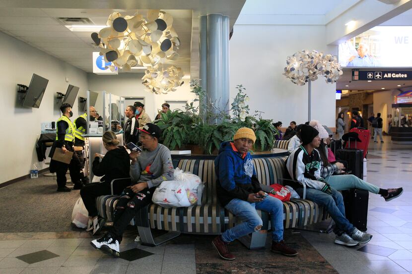 At the El Paso International Airport, some migrants waited for their flights. They were...