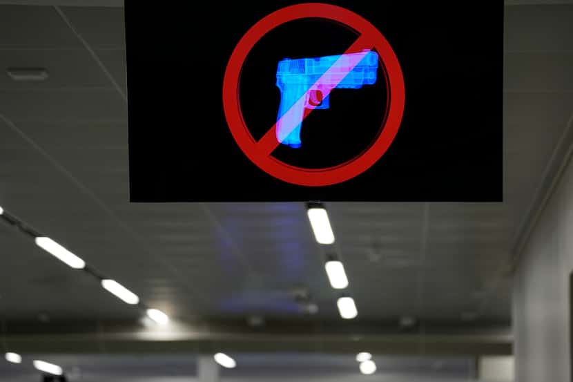 Una pantalla muestra un aviso de prohibición de armas en el control de seguridad del...