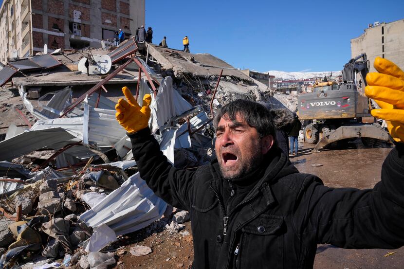 A man reacts, after rescue teams found his father dead under a collapsed building, in...