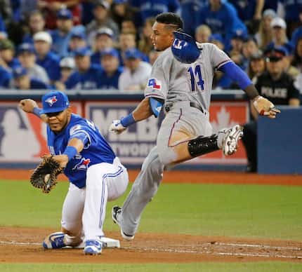 Texas Rangers left fielder Carlos Gomez (14) is out at first on a close play as Toronto Blue...