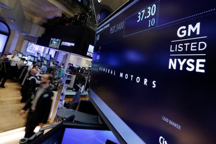 A trader passes the post that handles General Motors on the floor of the New York Stock...