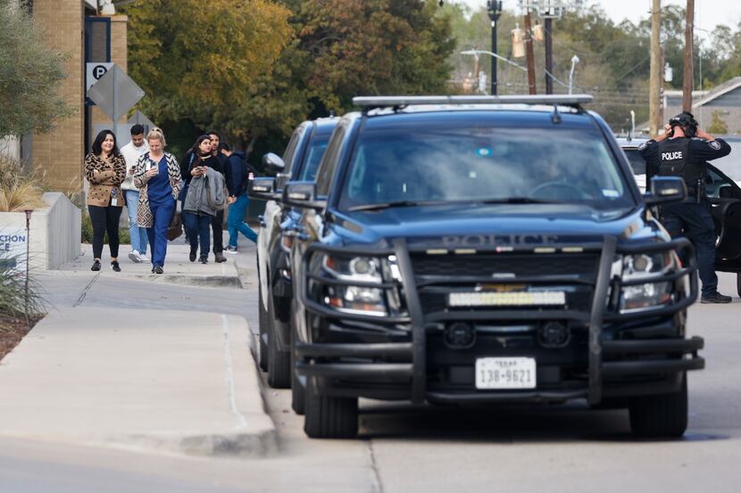 People walk around as police cars remain on the scene after no threat was found at UNT’s...