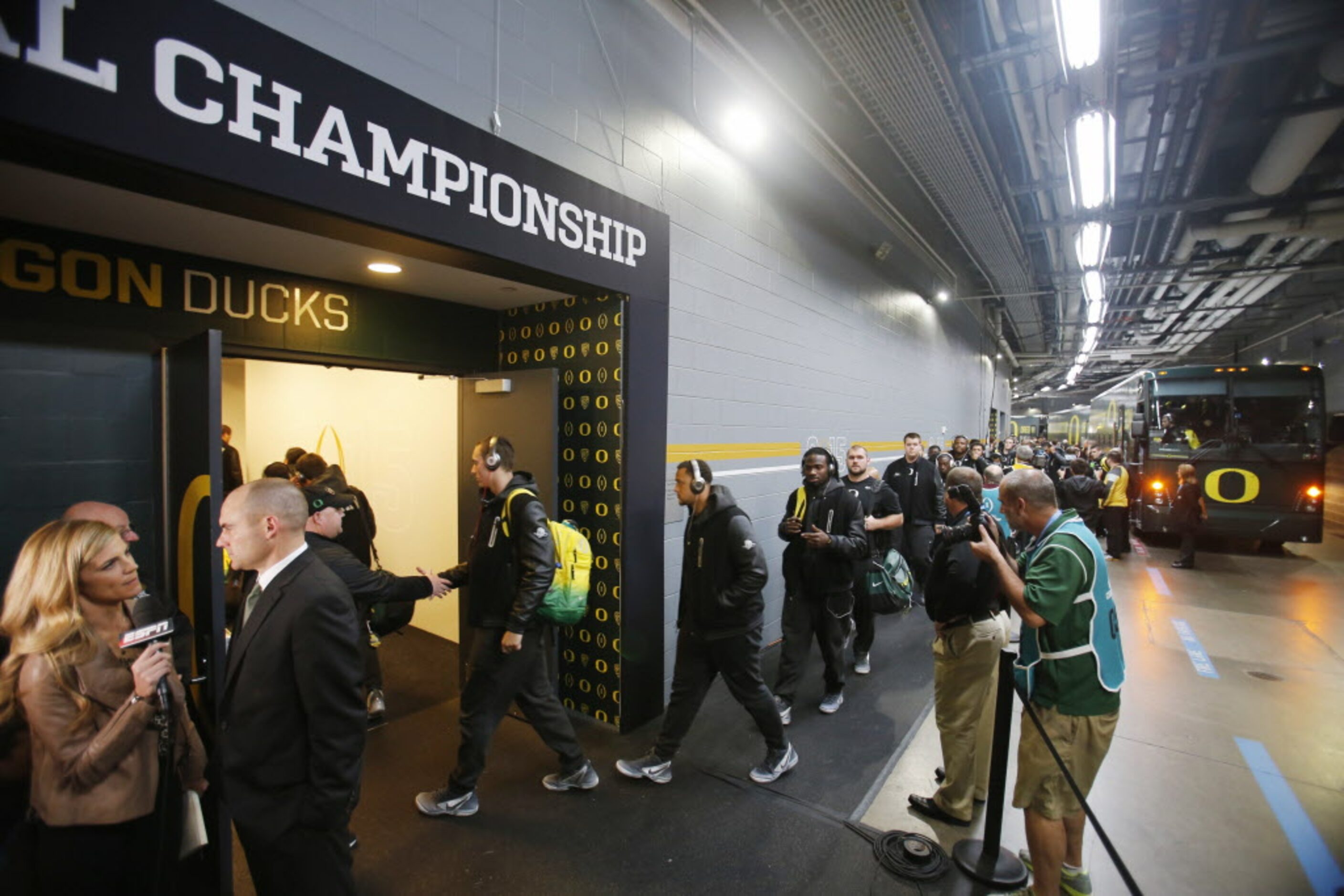 Oregon Ducks head coach Mark Helfrich conducts an interview as the rest of the team makes...