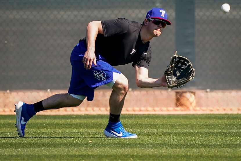 Texas Rangers infielder Nick Solak shags balls in center field during a spring training...