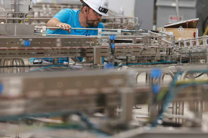 Brett Howard works on a conveyer belt that'll soon carry SunOpta products through a sterile...