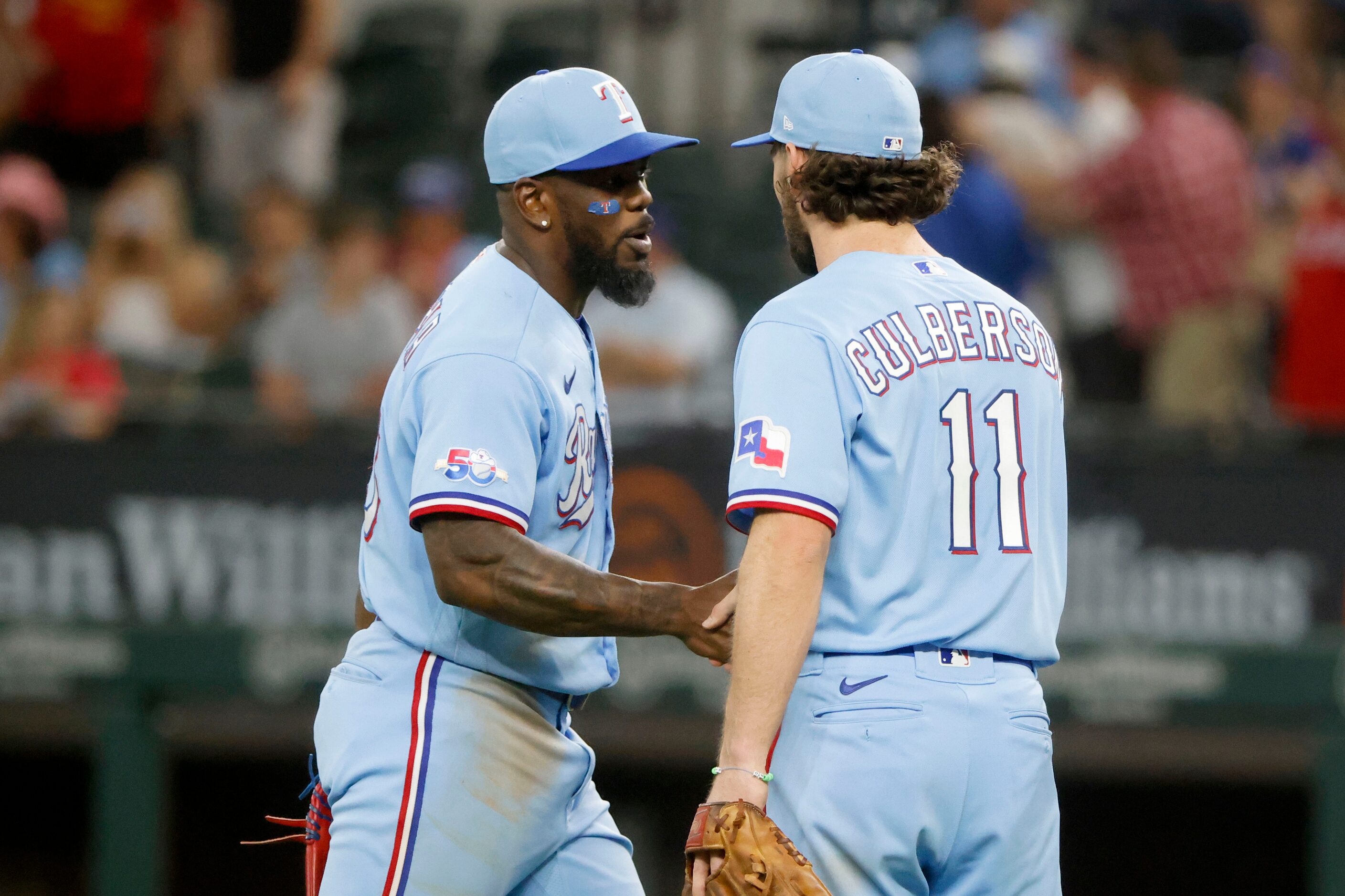 Texas Rangers Adolis Garcia, left and Texas Rangers’ Charlie Culberson (11) celebrate their...