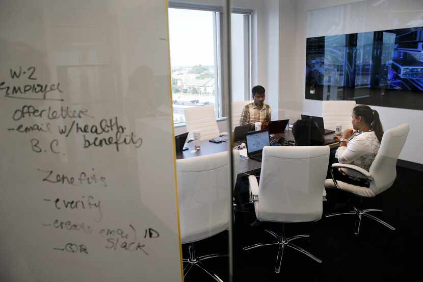 Wazid Shaik (left), Rini Ronald (center) and Yameen Fatima (right) work in a conference room...