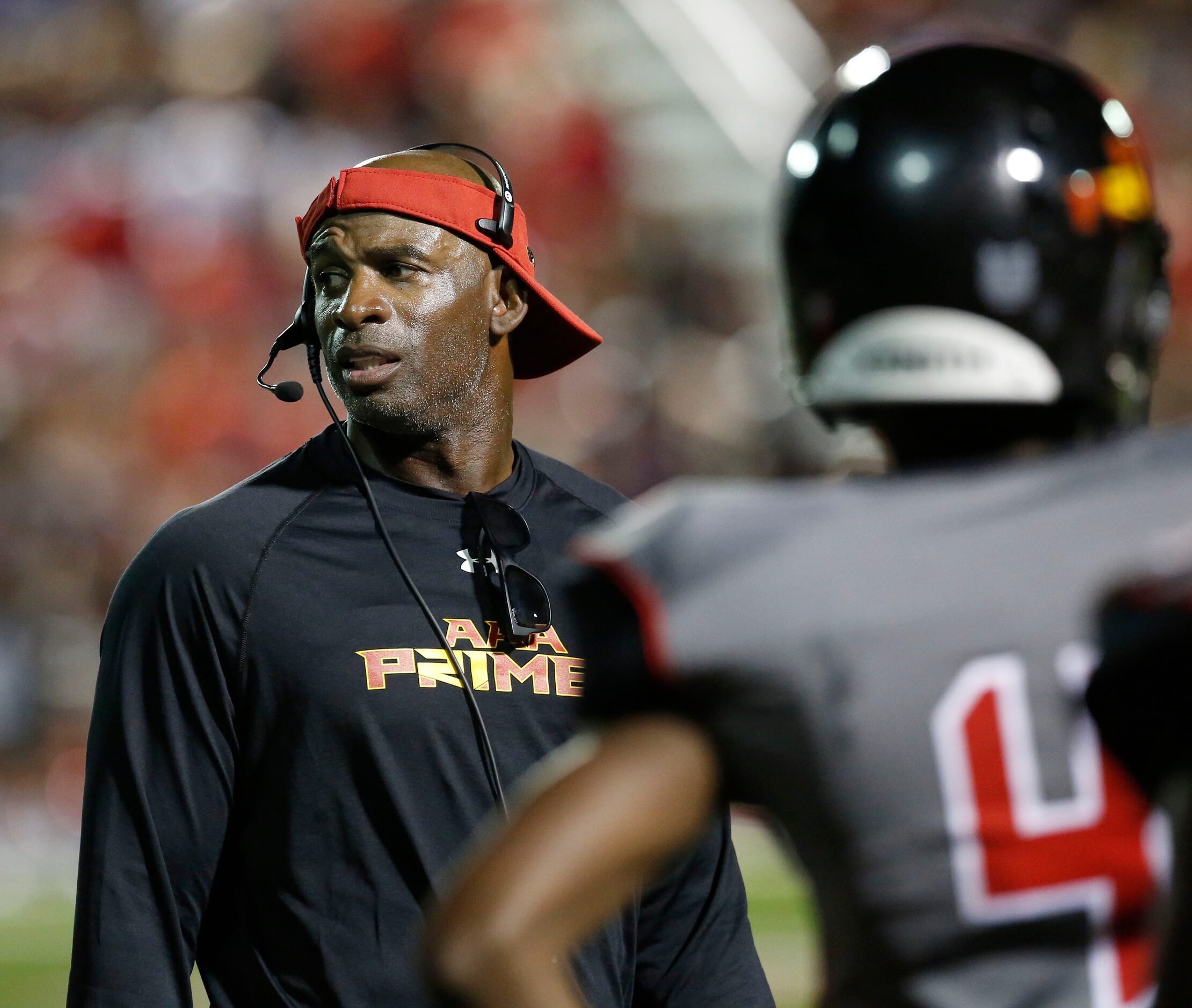 AAA Prime U coach Deion Sanders communicates with his players in the first half during a...