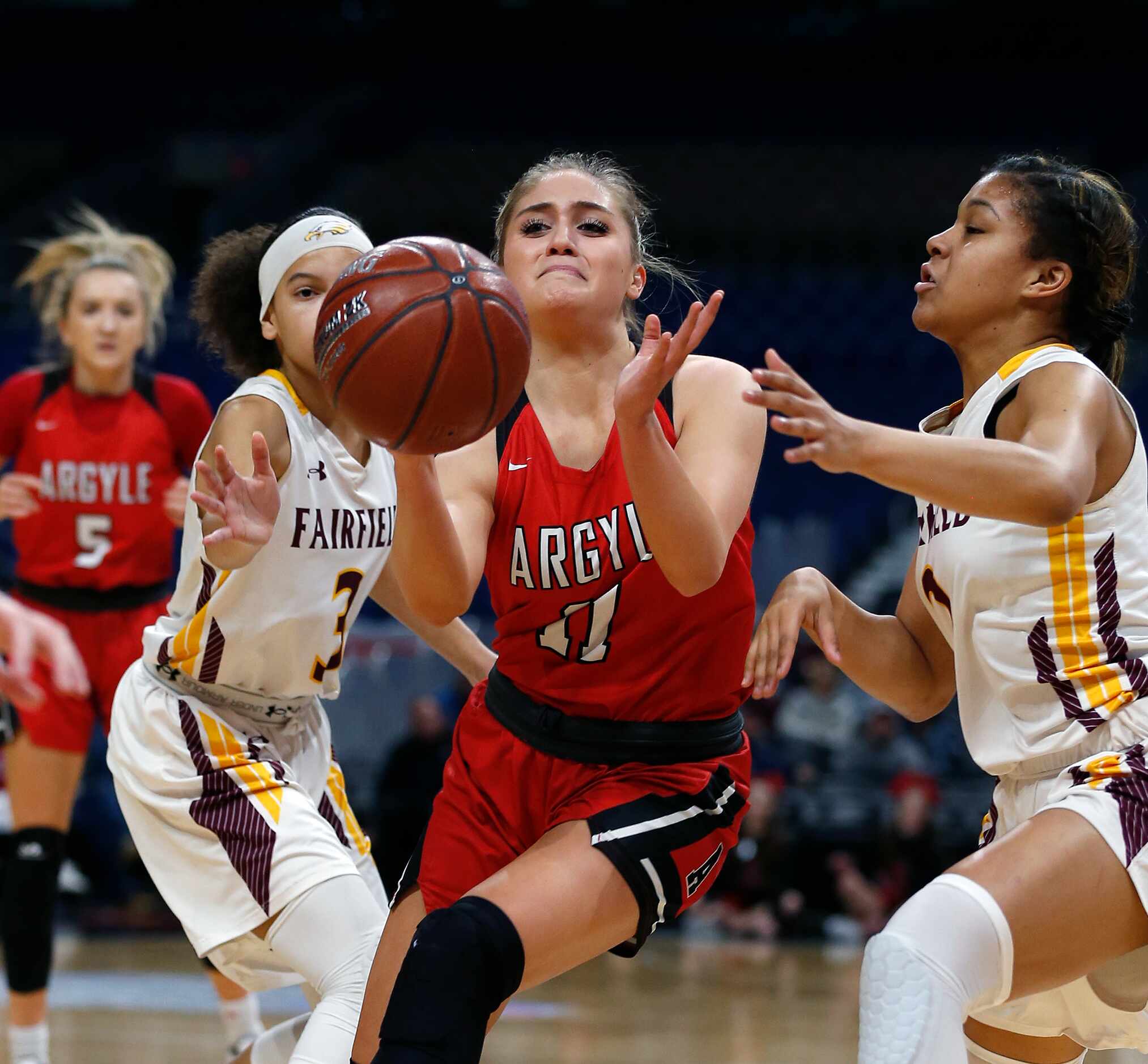 Argyle guard Brooklyn Carl #11 passes off next to Fairfield guard Jarahle Daniels #3 in a 4A...